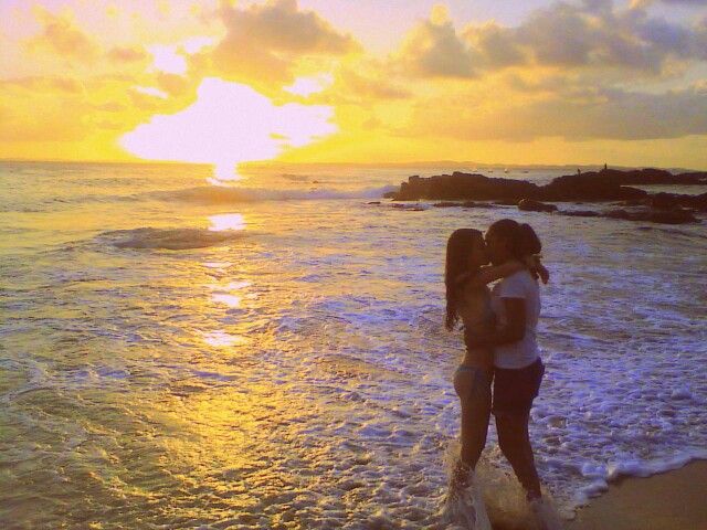 girls like girls in the sea at sunset kiss
